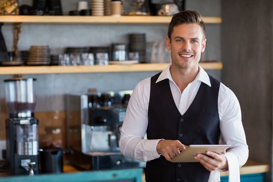 Waiter holding digital tablet in restaurant