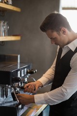 Waiter using coffee machine