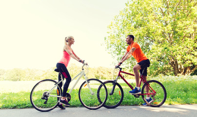 happy couple riding bicycle outdoors
