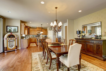 Classic American dining room with wooden table set, hardwood floor and rug.