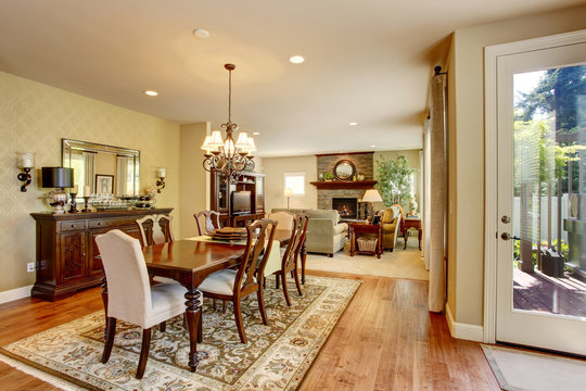 Classic American dining room with wooden table set, hardwood floor and rug.