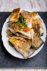 Fried fish with golden crust on a white plate