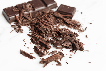Chopped dark chocolate on white background