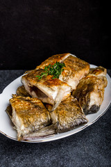 Fried fish with golden crust on a white plate