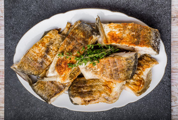Fried fish with golden crust on a white plate
