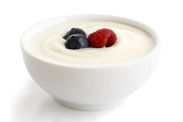 Ceramic bowl of white yoghurt with berries.