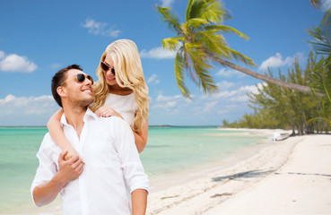 happy couple in sunglasses over summer beach