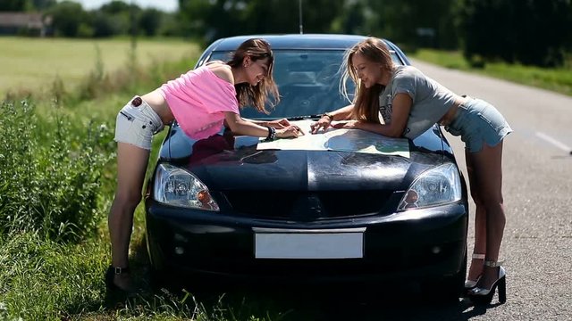 women on vacation looking at map for directions