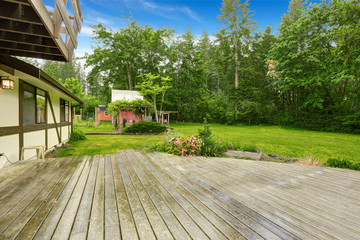 View of wooden walkout deck with patio area.