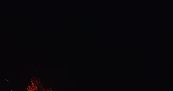 fire and sparks from bbq grill brazier fast rise over dark background