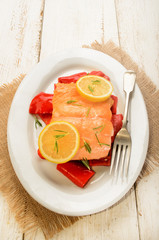 roasted salmon filet on red paprika, with lemon and rosemary