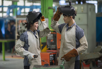 Man and woman welding in factory.industrial worker.