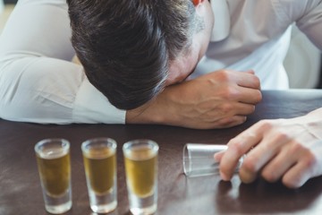 Drunken man sleeping on a bar counter