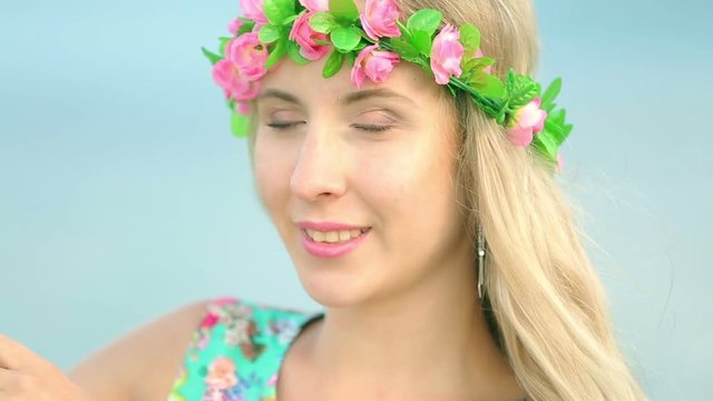 Portrait of attractive girl with flower wreath on her head. Beautiful woman with flower wreath.