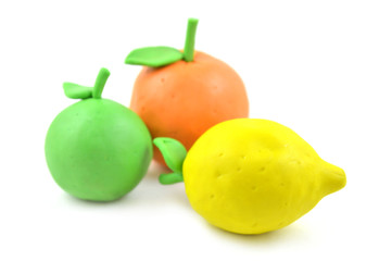 Plasticine citrus fruit on white background