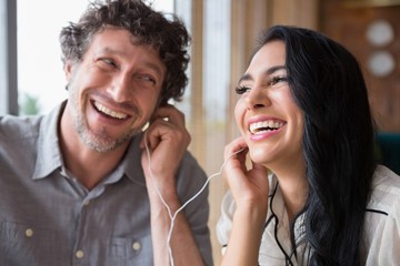 Couple listening to music together in cafeteria
