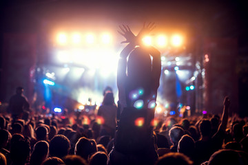 Girl on shoulders in the crowd at a music festival.