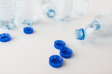 close up of empty water bottles and caps on table