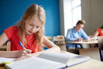 student girl with book writing school test