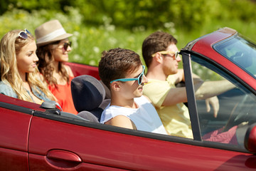 happy friends driving in cabriolet car