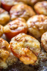 Pomodori rossi  tagliati orizzontalmente ripieni e gratinati