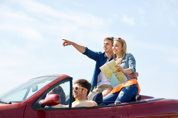 happy friends driving in cabriolet car