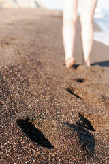 Footsteps on the black sand