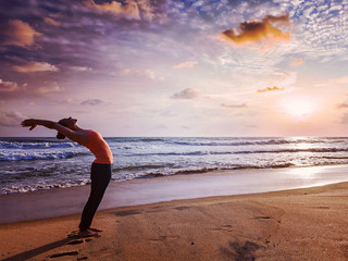 Fototapeta na wymiar Young sporty fit woman doing yoga Sun salutation Surya Namaskar