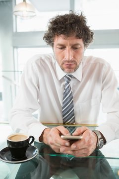 Businessman text messaging on mobile phone