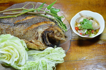 deep fried fish dipping chili fish sauce and vegetable on dish