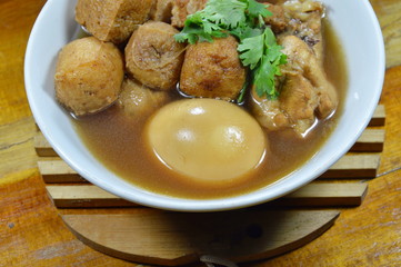 boiled egg with tofu and chicken in Chinese herb brown soup on bowl