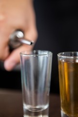 Waiter making shots at bar counter