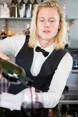 Waiter pouring wine into glass
