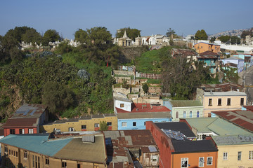 Colourfully decorated houses crowd the hillsides below a historic cemetery of the historic port city of Valparaiso in Chile.