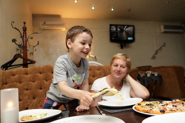 Grandmother with grandson eating pizza