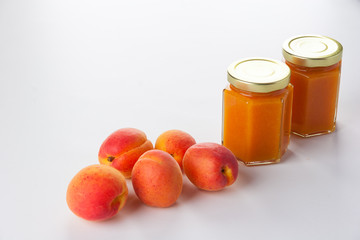 Apricot preserve and fruit on a white background