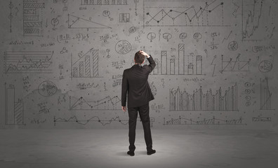 Salesman with business charts on wall
