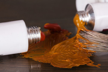 Open tubes of brown paint and brushes