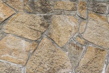 Yellow stone tiles on the wall as background texture