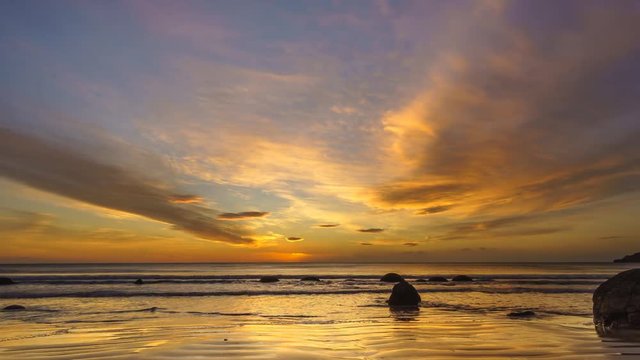 Vibrant Sunrise At Moeraki Boulders- Timelapse. Moeraki Boulders are a group of large spherical stones that have been exposed through shoreline erosion on Koekohe Beach near Moeraki. Zoom In