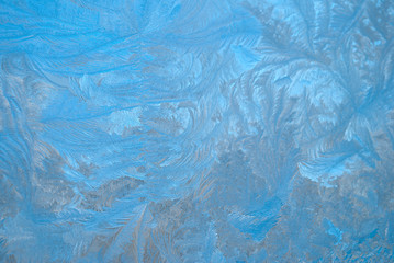 Slightly blurred beautiful frost pattern on a window glass (as an abstract winter background)