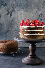 Naked chocolate cake with raspberries, strawberries and blueberries. Process prepation cake. Sponge...