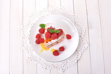 Waffles in shape of heart with raspberries and honey on white wooden table. Top view.