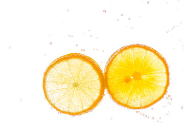 Fresh orange slice in water with bubbles on white background