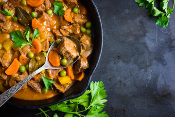 beef stew with vegetables on dark background