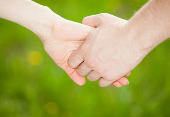 Hands of man and woman holding together