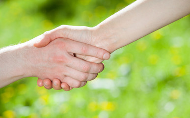 Hands of man and woman holding together