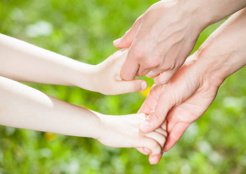 Hands of parent and child holding together