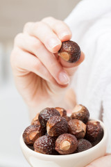 Woman hand holding bowl with soapnuts