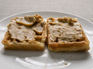 Waffle covered with peanut butter.